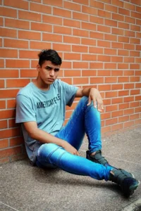 a teen sitting by a wall