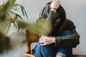 upset-lady-embracing-knees-sitting-on-chair