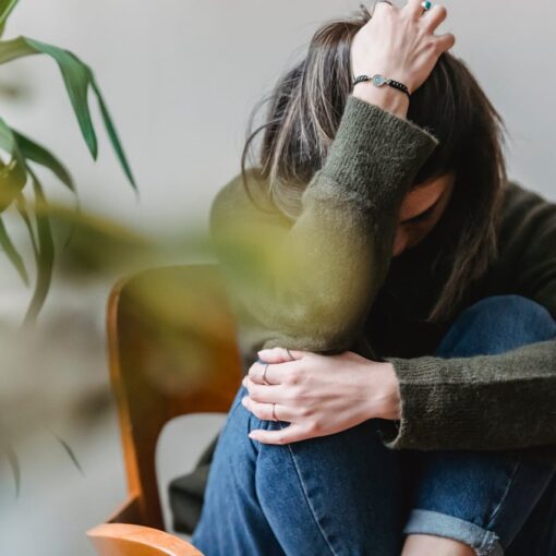 upset-lady-embracing-knees-sitting-on-chair