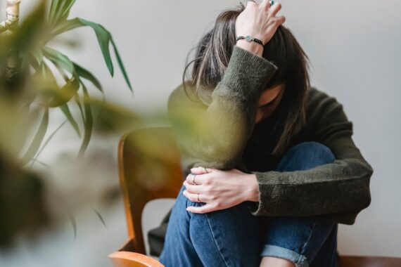 upset-lady-embracing-knees-sitting-on-chair